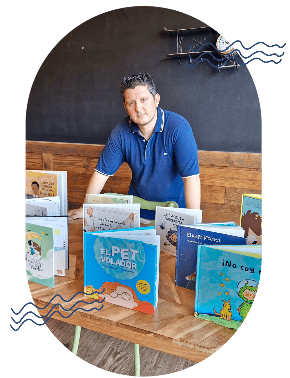 Hombre frente a una mesa con libros infantiles.